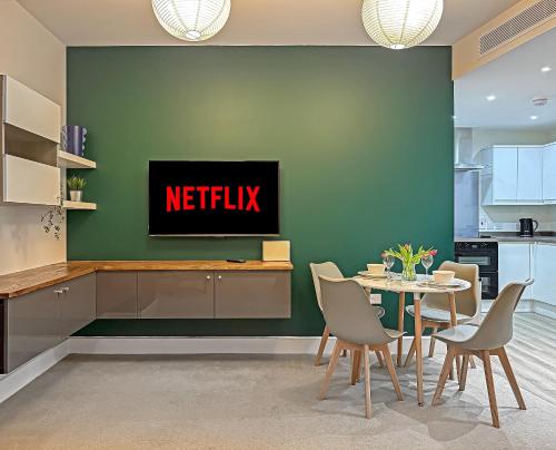 a kitchen and dining room with a netflix sign on a wall at PRIME CITY CENTRE MK STAY, Stylish Spacious Apartment, AIR CONDITIONG, Two bathrooms, FREE GATED ALLOCATED PARKING & Lift access in Milton Keynes