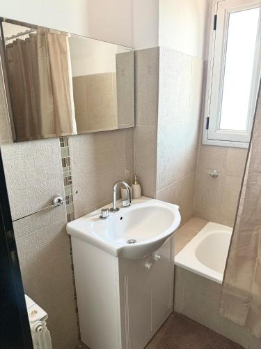 a white bathroom with a sink and a bath tub at R Haus 2 Con Cochera in Concordia