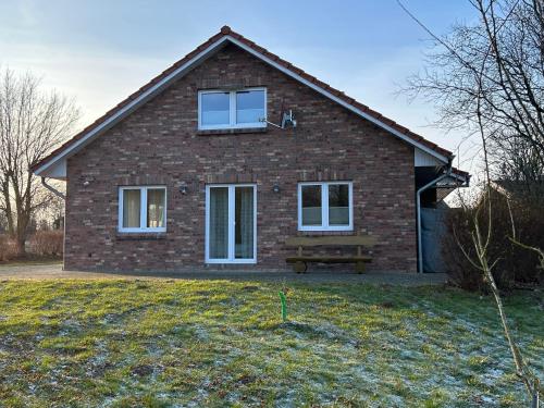 a brick house with a bench in front of it at Ferienhaus Tutsch Ostblick in Wangels