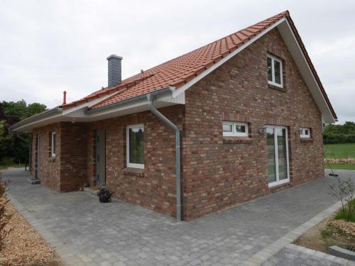 a brick house with a red roof at Ferienhaus Tutsch Westblick in Wangels