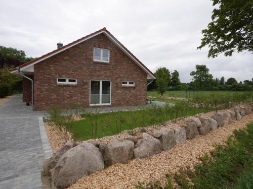 a brick house with a row of rocks in front of it at Ferienhaus Tutsch Westblick in Wangels