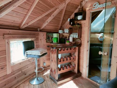 a bar in a log cabin with a stool at Magic Kota - Sternenguckerhaus in Wilhelminenthal