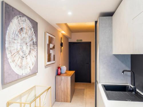 a kitchen with a sink and a hallway with a door at Mercury Suites Premium Apartments With Pool Access in St. Julianʼs