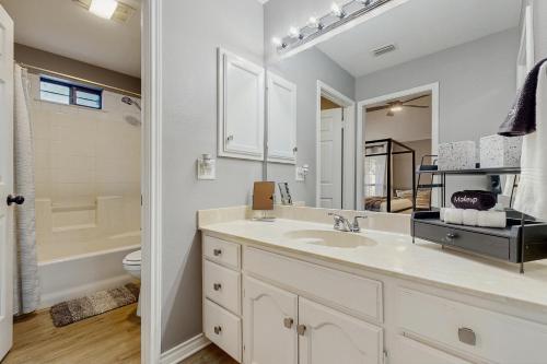 a white bathroom with a sink and a toilet at Stunning Rivrefront 3BR with Hot tub, water view! in Seguin