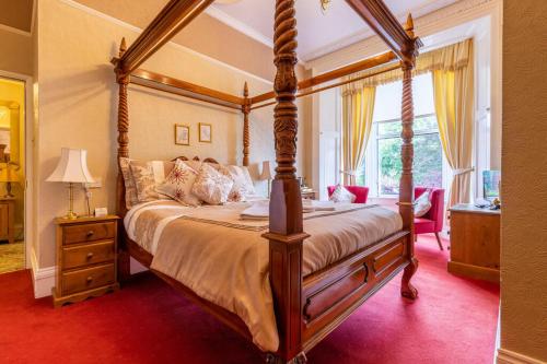 a bedroom with a four poster bed and a window at Glendale Guest House in Penrith