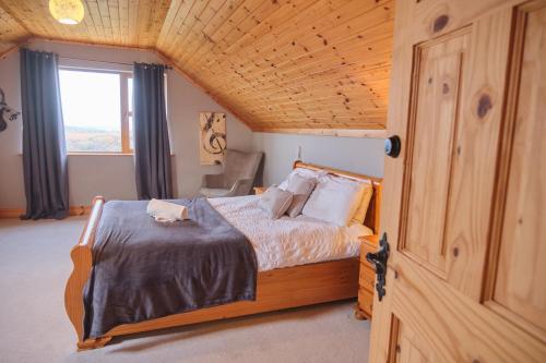 a bedroom with a bed in a wooden room at 5 Bedroom House By Travel Lets Holiday Homes Donegal With Sweeping Lake & Hill Views in Carrigart