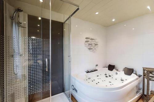 a bathroom with a tub and a glass shower at La Ressource in Cherain