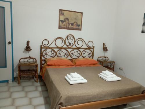 a bedroom with a bed with two towels on it at Villetta Generosa in Torre Lapillo