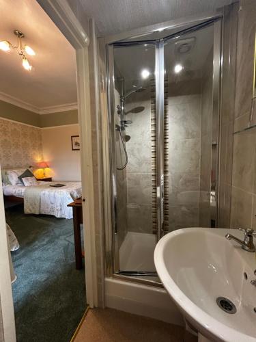 a bathroom with a shower and a sink at Glendale Guest House in Penrith
