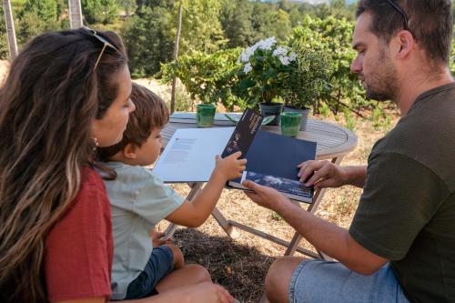 a man and a woman and a child looking at a laptop at Casa Fermil da Graça in Veade