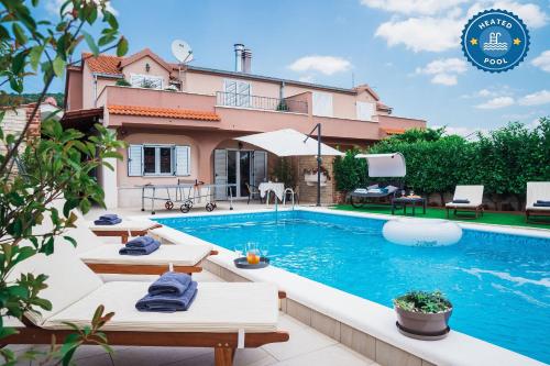 a villa with a swimming pool in front of a house at Villa Peaceful Valley in Šestanovac
