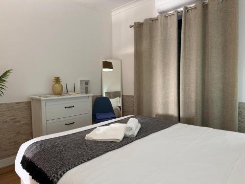 a bedroom with a bed with a mirror and a chair at Azores Pedra Apartaments A in Fajã de Baixo