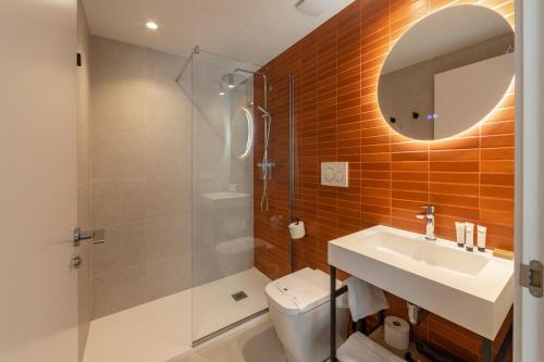 a bathroom with a toilet and a sink and a mirror at Ahoy Plaza Mayor in Elda