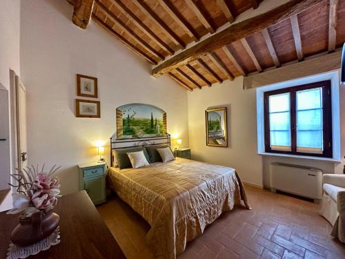 a bedroom with a bed and a large window at La Pietra Dorata in Rapolano Terme