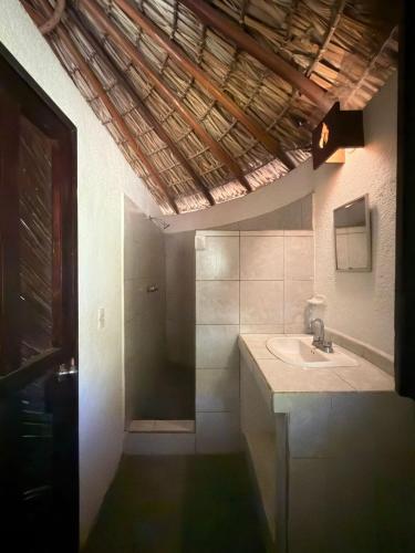 a bathroom with a sink and a shower at Shalom Backpacker Hostel in Puerto Escondido