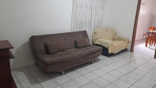 a couch and a chair in a living room at José Nilton in Imbituba