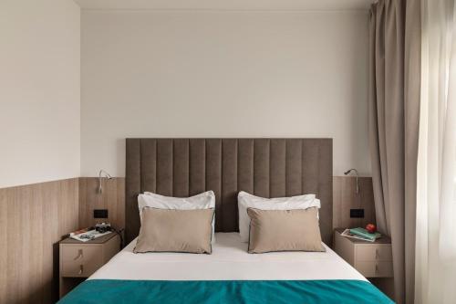 a bedroom with a large bed with a large headboard at Living Hotel Milano in Cornaredo