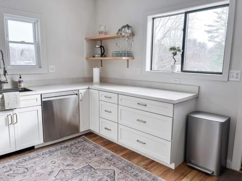 a kitchen with white cabinets and a sink and a window at Kenoza House with Private Lake and Kayaks in Callicoon