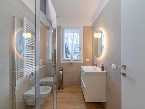 a bathroom with a sink and a toilet and a mirror at GINO SUITES - Monolocali Luxury - Appartamenti vicini a Rho Fiera e Milano in Bollate