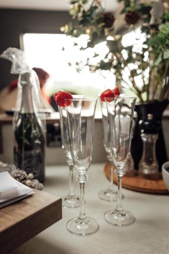 three wine glasses with a strawberry in them on a table at Rose Meadow Lodge in Liscannor