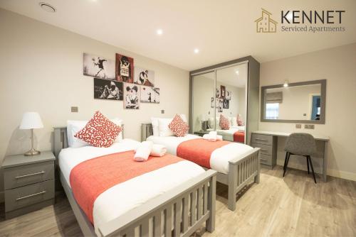 a bedroom with two beds and a desk and a mirror at Chester House in Reading