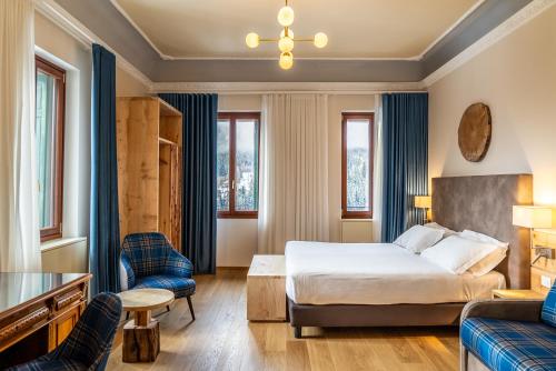 a hotel room with a bed and a couch at TH Borca di Cadore - Park Hotel Des Dolomites in Borca di Cadore