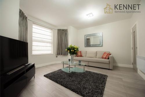 a living room with a couch and a tv at Laurel House in Reading