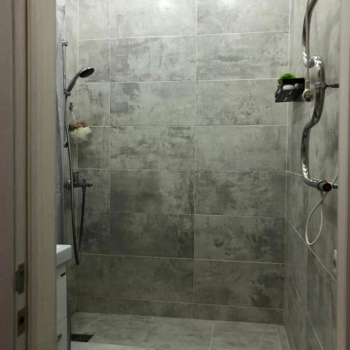 a shower in a bathroom with a tiled shower at ЖК 'Арман ' in Aktobe