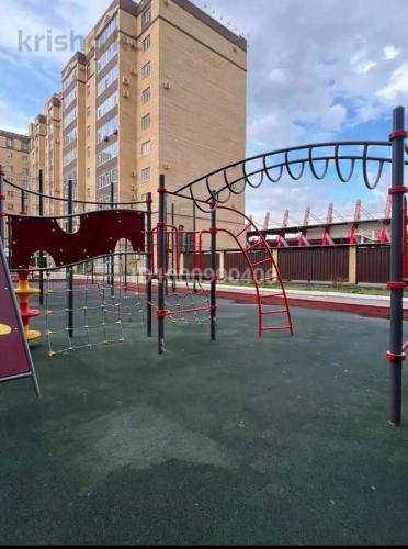 an empty playground with a slide in a park at ЖК 'Арман ' in Aktobe