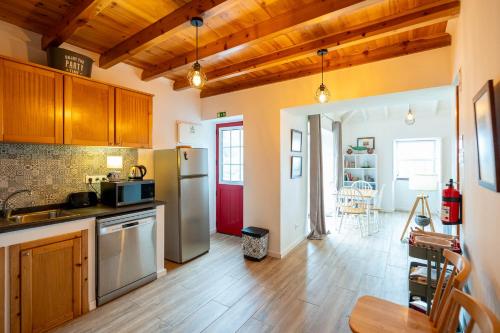 a kitchen with a refrigerator and a table in it at Liiiving in Açores - Casa de Foros in Foros