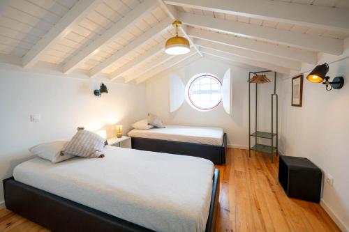 a bedroom with two beds and a window at Liiiving in Açores - Casa de Foros in Foros