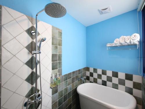 鵝鑾的住宿－蔚藍海舍，浴室配有浴缸和淋浴,拥有蓝色的天花板