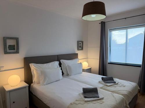 a bedroom with a bed with two towels on it at AZORES PEDRA APARTMENTS - T0 e T1 in Ponta Delgada