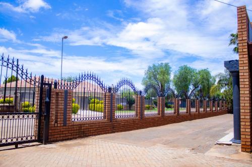 a red brick fence with a gate in a park at Travel Shift Accommodation in Northam