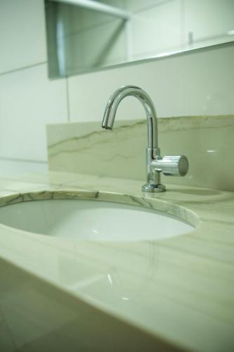 a sink with a faucet in a bathroom at Mimari Hotel in Tangara da Serra