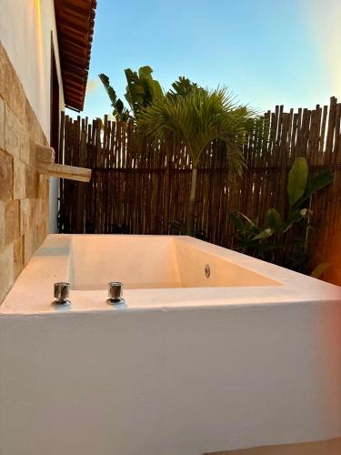 a white bath tub in front of a fence at Chalé Caju Knots in Parajuru