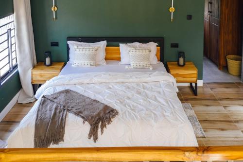 a large bed in a bedroom with a green wall at Starico Residence in Nkoanrua