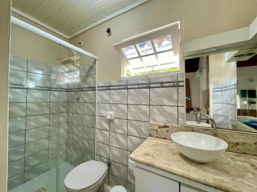a bathroom with a sink and a toilet and a shower at Atobá Villas in Paraty