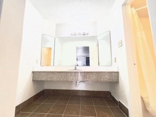 a bathroom with a sink and a mirror at Airport Inn in Tulsa