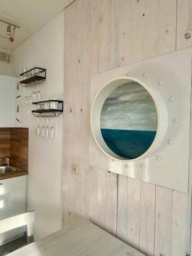 a kitchen with a circular painting on the wall at FeWo GüNi Marina Wendtorf Strand mit Balkon und seitlichem Fördeblick in Wendtorf