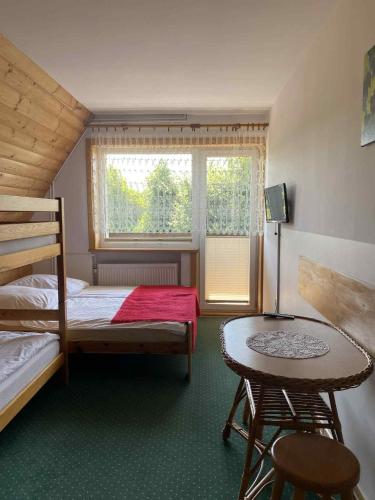 a bedroom with a bunk bed and a table at Pokoje u Teresy in Czarna Góra