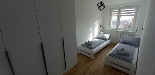a bedroom with two beds and a window at Apartament 7 Piętro in Wałbrzych