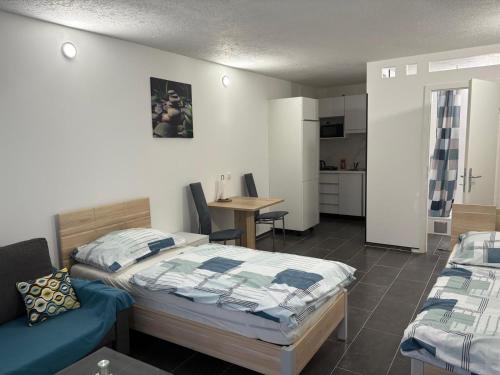 a bedroom with two beds and a table and a kitchen at Apartmani Ela 2 3 in Sierning