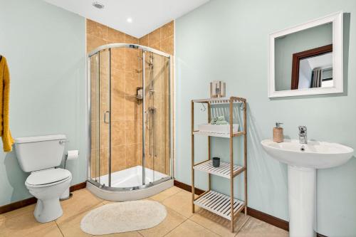 a bathroom with a shower and a toilet and a sink at Mullaghmore Holiday Home in Cliffony