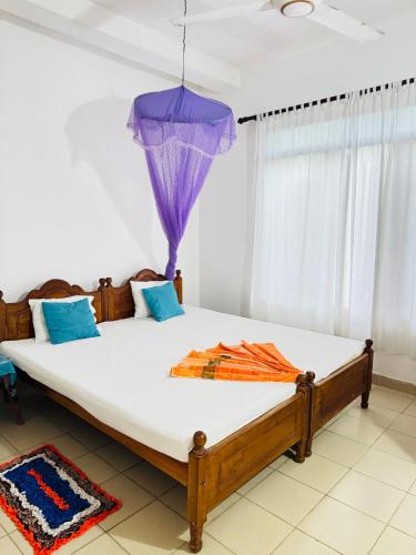 a bedroom with a large bed with a purple ceiling at Moragalla Relax Stay in Beruwala