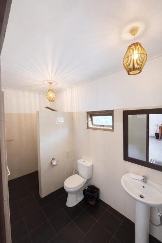 a bathroom with a toilet and a sink at The Jungle Pearl Hotel in Udawalawe