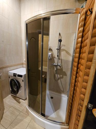 a glass shower in a bathroom with a washing machine at Хостел Палац Спорта in Kyiv