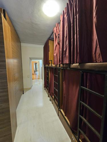 a long hallway with wooden shelves and a room with a hallway at Хостел Палац Спорта in Kyiv