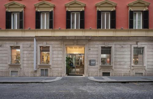 ein Gebäude mit einem roten Gebäude mit Fenstern in der Unterkunft Leonardo Boutique Hotel Rome Monti in Rom