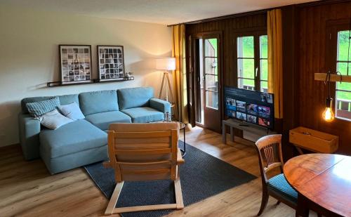 a living room with a blue couch and a table at Chalet Oasis - Your Alpine Hideaway in Bürglen